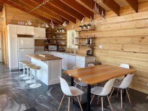 een keuken met houten wanden en een houten tafel en stoelen bij Chalet L'Orée Étoilée in La Tuque