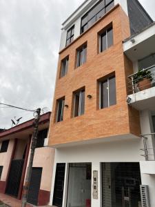 un bâtiment en briques brunes avec une fenêtre dans l'établissement Hotel El Cedro Exclusive, à Florencia