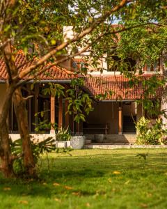 a house with a tree in front of it at Origin Balapitiya- Family Villa 200m From Beach in Balapitiya