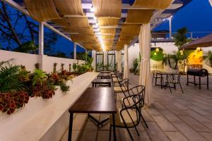 a patio with tables and chairs and plants at Sol Flow Retreat in Nguyên Ngoại