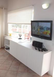 a white kitchen with a flat screen tv on the wall at Großes Modernes Ferienapartment Villa Atlantico in La Pared +32 photos