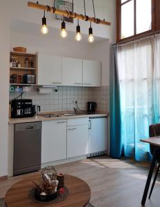a kitchen with white cabinets and a table at Charmante Wohnung In Langfurth Mit Kleinem Balkon in Schöfweg