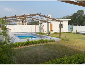 una piscina en un patio con una casa en Monal by Shubhs, en Jāmb