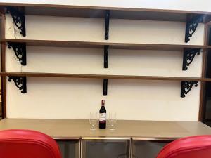 Una botella de vino sobre una mesa con dos copas. en Monal by Shubhs, en Jāmb