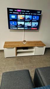 un téléviseur à écran plat posé sur un mur dans un salon dans l'établissement Studio Harmony with pool, à Baie Nettlé