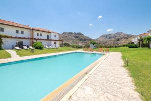 ein Swimmingpool in einer Villa mit Bergen im Hintergrund in der Unterkunft Haus In Kolympia Mit Garten Und Schöner Aussicht in Kolymbia
