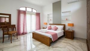 a bedroom with a bed and a table and a desk at Silva Villa Negombo in Negombo