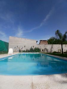 a swimming pool with blue water in front of a building at SUKHA in Baradero