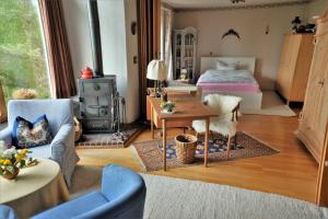 ein Schlafzimmer mit einem Bett und einem Tisch in einem Zimmer in der Unterkunft Auf einem großen Grundstück gelegenes Ferienhaus mit einer umwerfenden Panoramaaussicht in Glotzdorf