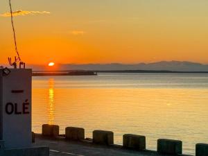 a sunset over a body of water with the sun setting at OLÉ Villa in Xiyu