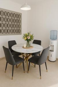 CancinoOne bedroom,central location Wifi&Ac的桌子上摆放着椅子,花瓶上放着花