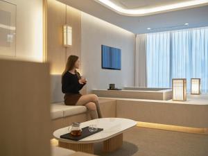 a woman sitting on a couch in a room at UH Suite The Coex in Seoul +53 photos