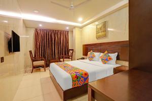 Una habitación de hotel con una cama, una mesa y una silla. en Hotel Continental Inn, en Chennai