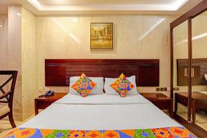 Un dormitorio con una gran cama blanca con almohadas de colores. en Hotel Continental Inn, en Chennai 19 fotos más