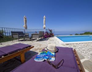 ein Hut und eine Sonnenbrille auf einem Tisch neben einem Pool in der Unterkunft Ferienhaus mit Privatpool für 8 Personen ca 150 m in Podgora, Dalmatien Mitteldalmatien in Podgora