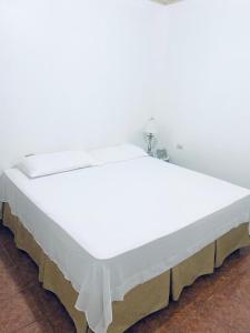 a large white bed in a room at Casa de Wen in Santa Rita