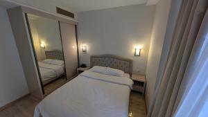 Un dormitorio con dos camas y un gran espejo. en Princess in Alliance Palace, en Batumi