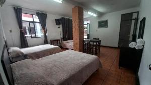 a hotel room with two beds and a table at Hotel Dulce Morelia in Morelia
