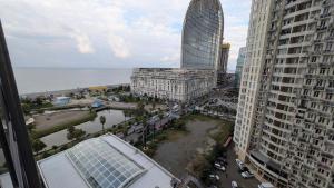 vistas a una ciudad con edificios altos y al océano en Princess in Alliance Palace, en Batumi