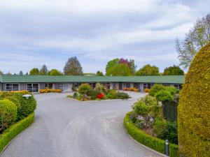 a building with a circular driveway with bushes at Andorra Motel in Geraldine