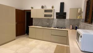 a kitchen with white cabinets and a stove top oven at Silva Villa Negombo in Negombo