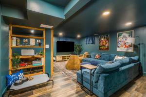 ein Wohnzimmer mit einer blauen Couch und einem Fernseher in der Unterkunft Fox&Hound Cabin: Cold Plunge, Sauna, Hot Tub, Dogs in Basye