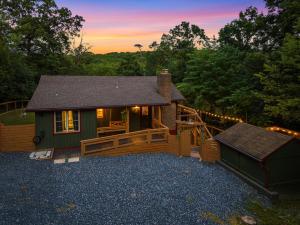 eine kleine Hütte mit Terrasse und einem Gebäude in der Unterkunft Fox&Hound Cabin: Cold Plunge, Sauna, Hot Tub, Dogs in Basye