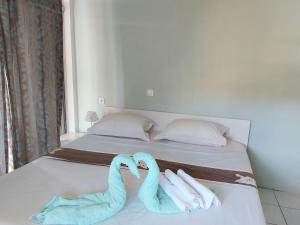 1 cama con 2 toallas en forma de corazón en Manuia Lodge, en Punaauia