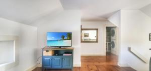a living room with a television on a blue cabinet at Old Orchard House in Brandon