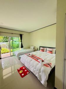 une chambre avec deux lits et une grande fenêtre dans l'établissement 3P Phuket Airport Hotel, à Phuket