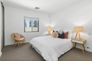 Una habitación blanca con una cama y una ventana en Welcome to Cottesloe Beach!, en Perth