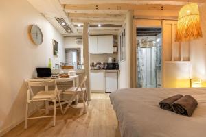 a bedroom with a bed and a desk and a kitchen at Blois hypercentre, calme, charme avec terrasse in Blois +14 photos