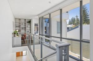 una escalera en una casa con ventanas de cristal en Welcome to Cottesloe Beach!, en Perth 6 fotos más