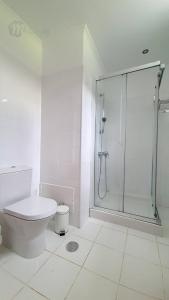 a white bathroom with a shower and a toilet at Luxuriöses Haus Der Leidenschaft in Machico +32 photos