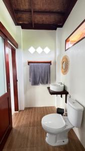 a bathroom with a toilet and a sink at Green Corner Villa in Bukit Lawang