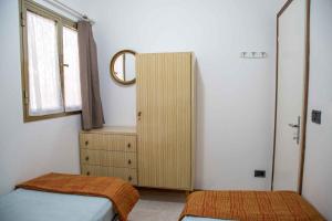 - une chambre avec 2 lits, un miroir et une commode dans l'établissement Holiday home in Eraclea Mare 25653, à Marina di Santa Croce