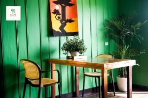 a table and chairs in a room with green walls at Balai Berde Baguio in Baguio