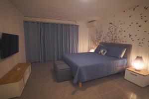 - une chambre dotée d'un lit bleu avec des oiseaux sur le mur dans l'établissement Studio Harmony with pool, à Baie Nettlé 7 autres photos