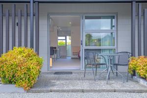 a patio with a table and chairs in front of a house at Andorra Motel in Geraldine