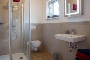 ein Badezimmer mit Waschbecken, Toilette und Dusche in der Unterkunft Ferienwohnung im Illertal in Altenstadt