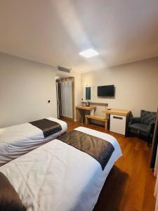 ein Hotelzimmer mit zwei Betten und einem Fernseher in der Unterkunft Tufad Prestige Boutique in Ankara