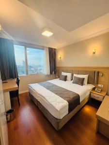 ein Hotelzimmer mit einem großen Bett und einem großen Fenster in der Unterkunft Tufad Prestige Boutique in Ankara
