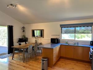 a kitchen with a table and a dining room at Famlee Ties in Venus Bay