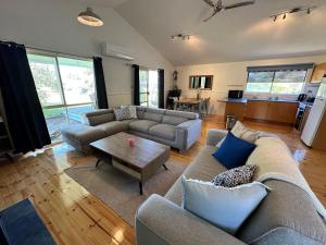 a living room with a couch and a table at Famlee Ties in Venus Bay