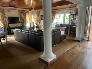 ein Wohnzimmer mit schwarzen Ledermöbeln und einer Säule in der Unterkunft Mooka in Pyramid