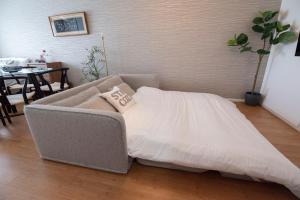 a bed in a living room with a table at kotinoma kuu in Hakozaki