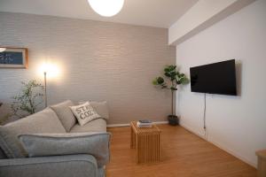 a living room with a couch and a flat screen tv at kotinoma kuu in Hakozaki