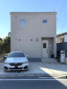 um carro branco estacionado em frente a um prédio em The Sealions 海獅a newly built home 2 mins walk from supermarket em Abiko