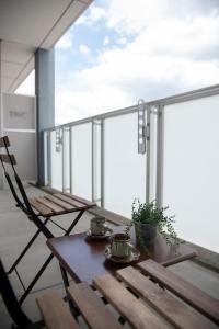 a balcony with a wooden table and two chairs at kotinoma kuu in Hakozaki
