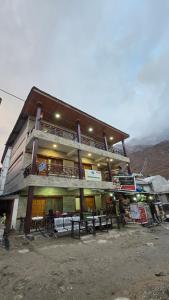 a building with tables and chairs in front of it at Shivpuri House Kedarnath in Kedārnāth